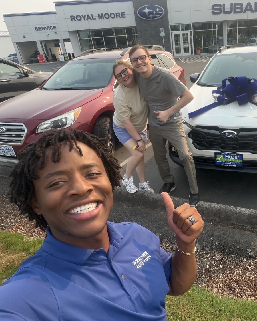 Artie Johnson with customers and their new white Subaru Crosstrek with a delivery bow