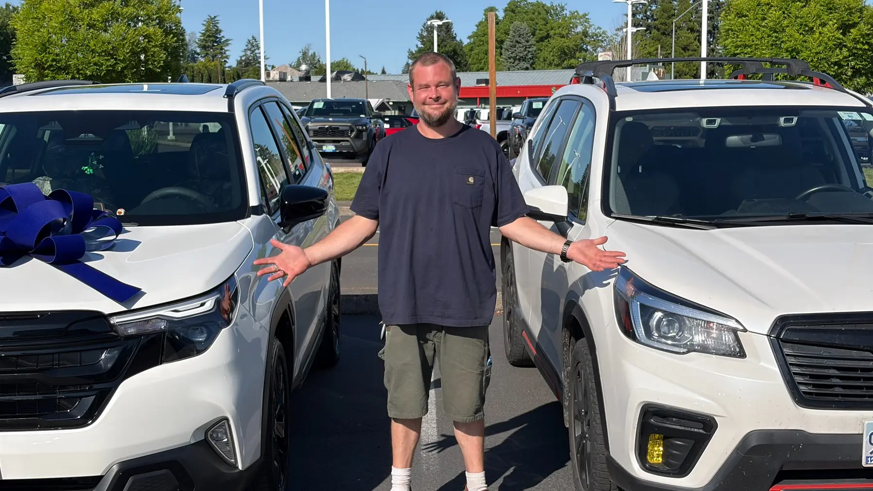 Customer comparing two white SUVs on the dealership lot